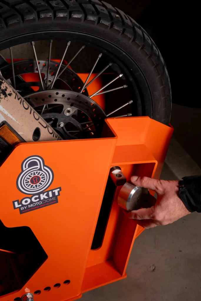 Hand operating the locking mechanism of a DockIT motorcycle stand