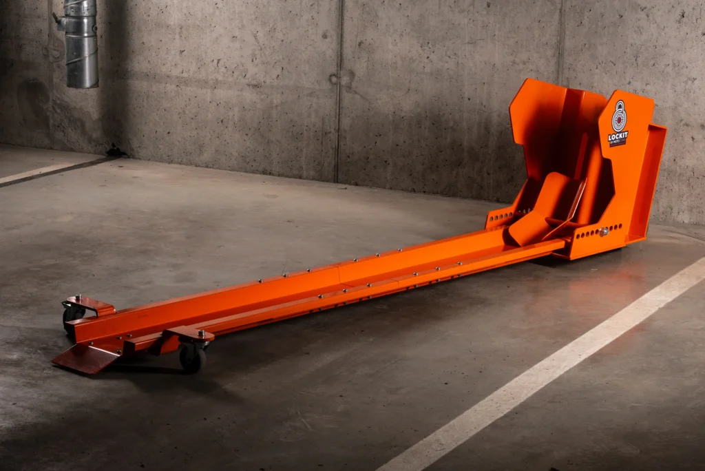 Orange DockIT rotating motorcycle parking stand on an underground car park floor