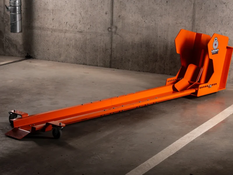 Orange DockIT rotating motorcycle parking stand on an underground car park floor