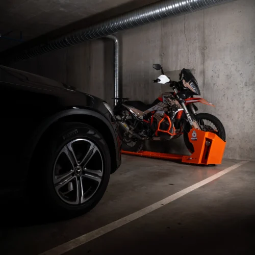 Motorcycle parked on a DockIT stand alongside a car within a single parking space