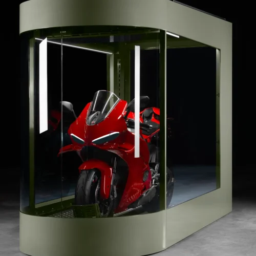 MotoDome glass walls with LED lighting MotoDome glass motorcycle garage lit by ambient LED lighting at night