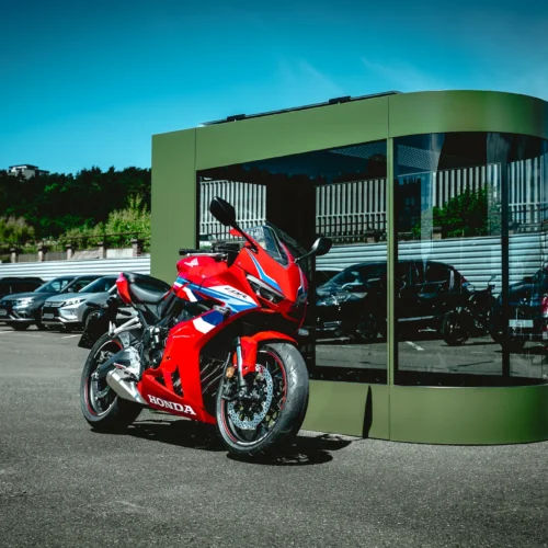 MotoDome outdoors in daylight Olive MotoDome motorcycle garage standing outdoors on a sunny day with a red sportbike inside