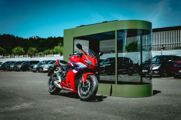 MotoDome outdoors in daylight Olive MotoDome motorcycle garage standing outdoors on a sunny day with a red sportbike inside