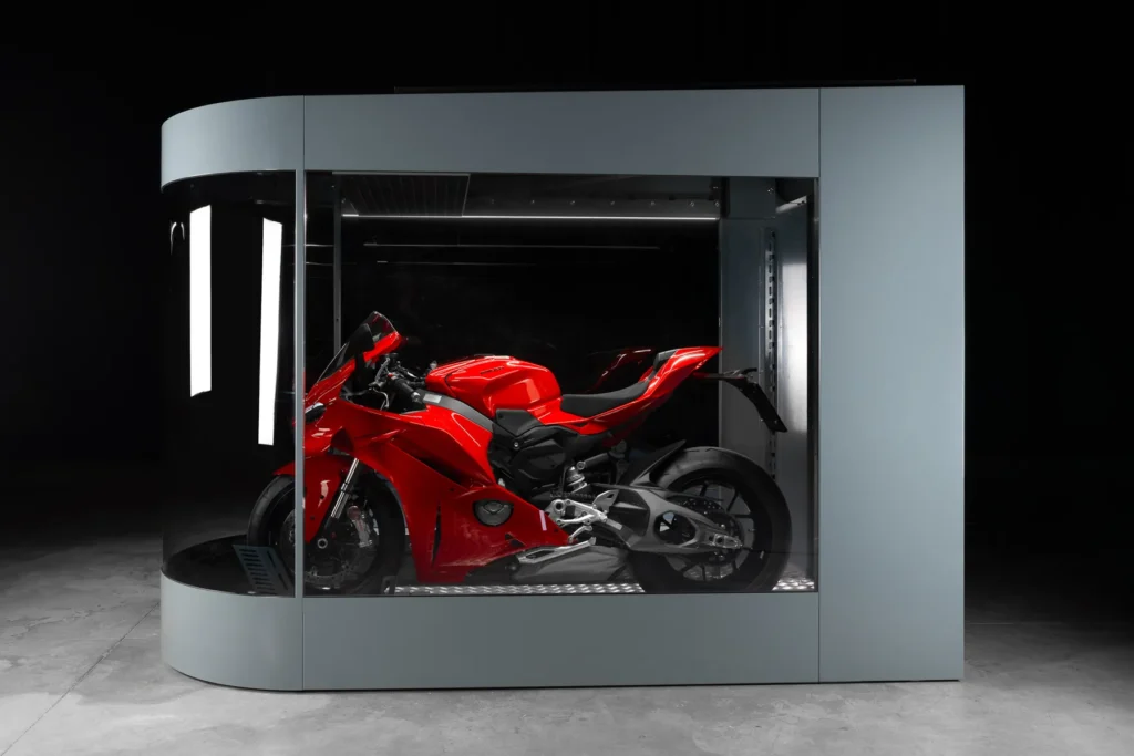 MotoDome garage lit from within so the motorcycle is displayed like a showroom piece